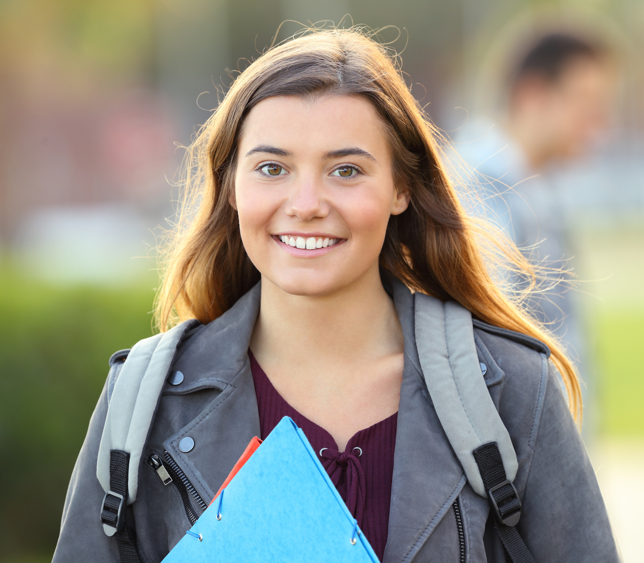 smiling student carrying backpack