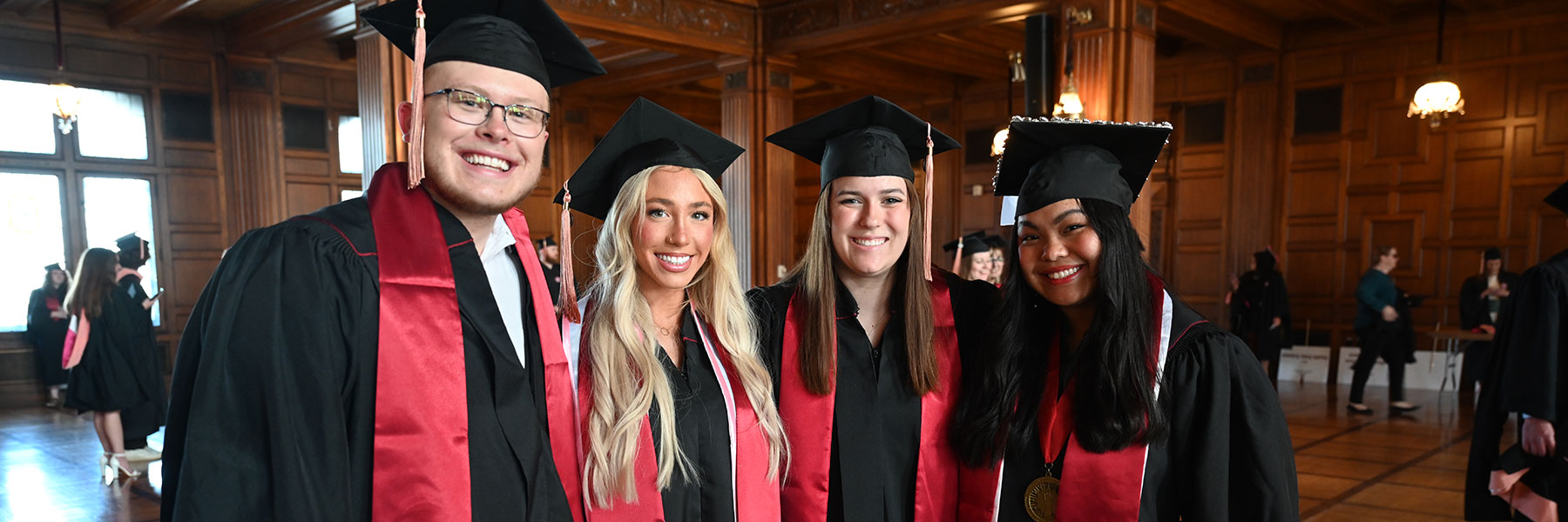 four public health students posing and smiling at commencement